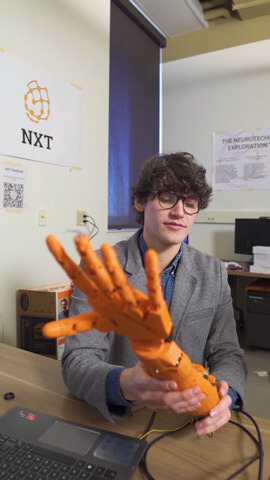 Harrison Canning working with a prosthetic hand.