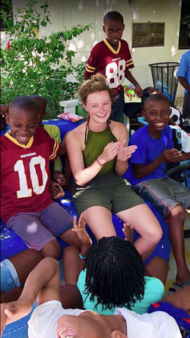 Katherine Duffy sitting with kids from a children's home in Haiti.