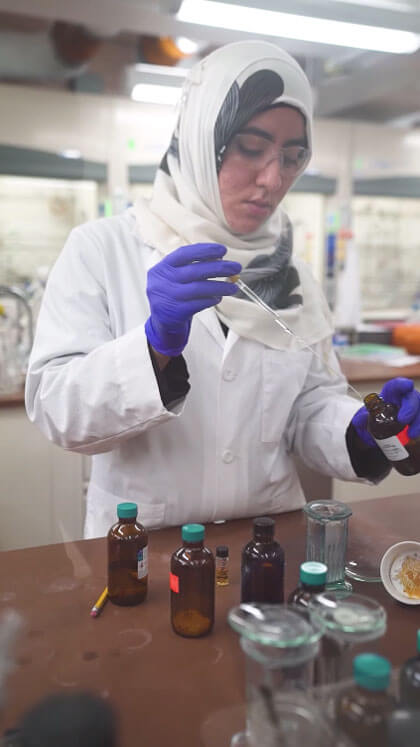 Zayneb Jaff using a syringe to transfer chemicals.