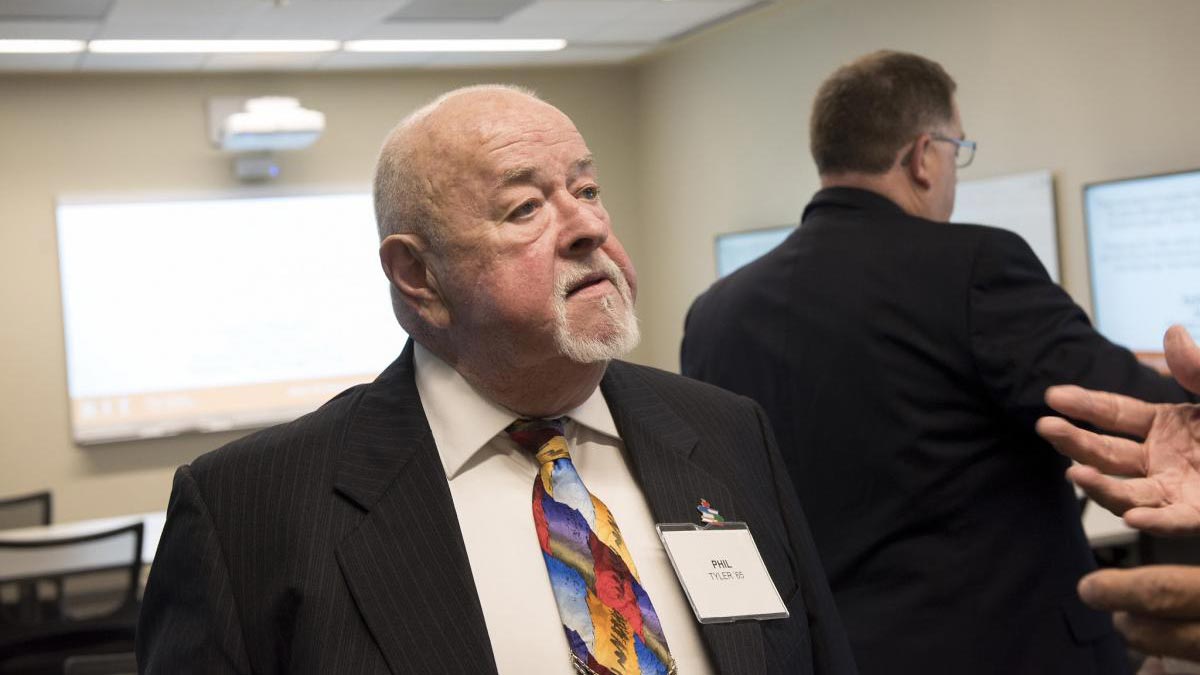 Dr. Philip R. Tyler wearing a suit with a name tag on.