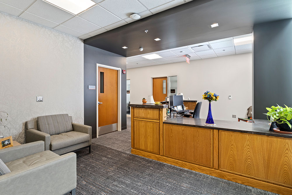 a reception area with soft seating and a large desk.