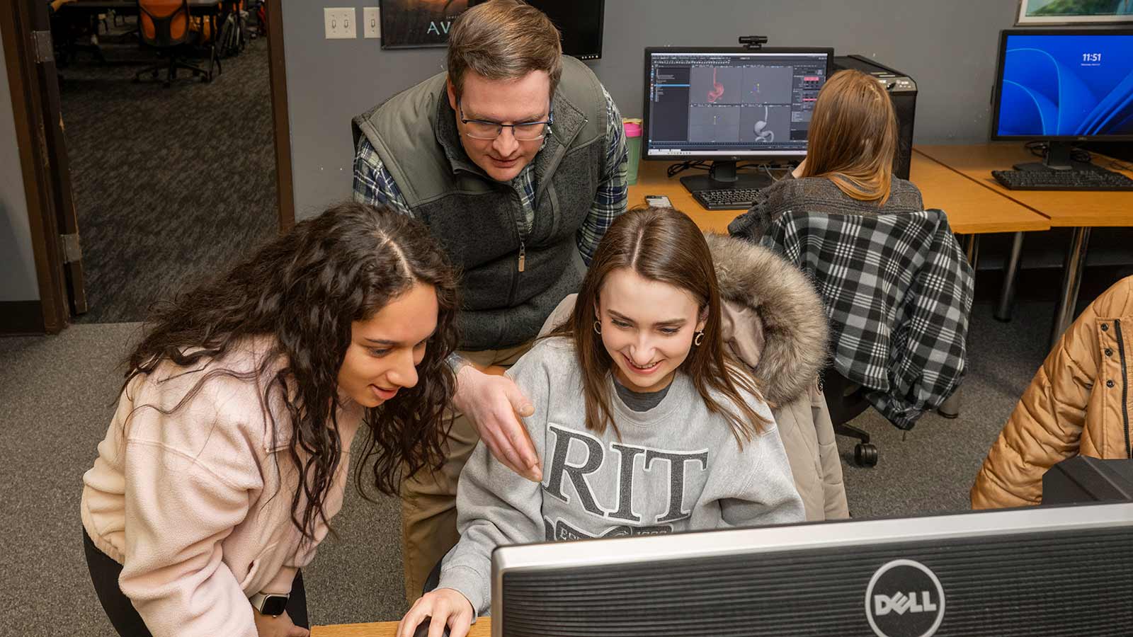 Alan Gasek instructs students while they work on a computer.