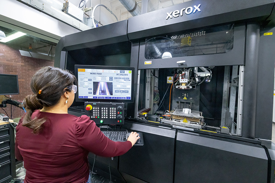 A grad student using a metal 3D printer in Brinkman Machine Tools and Manufacturing Lab