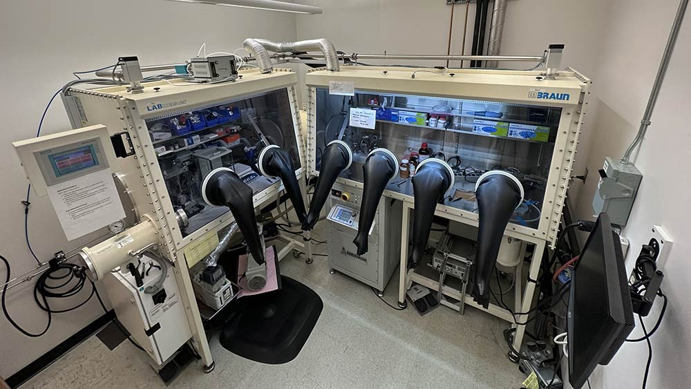 lab equipment with sensitive materials in glass cases accessible with large rubber gloves attached to the glass.