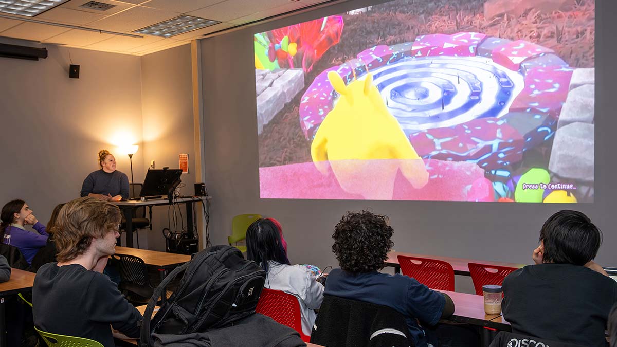 Students watch a projection on a large screen.