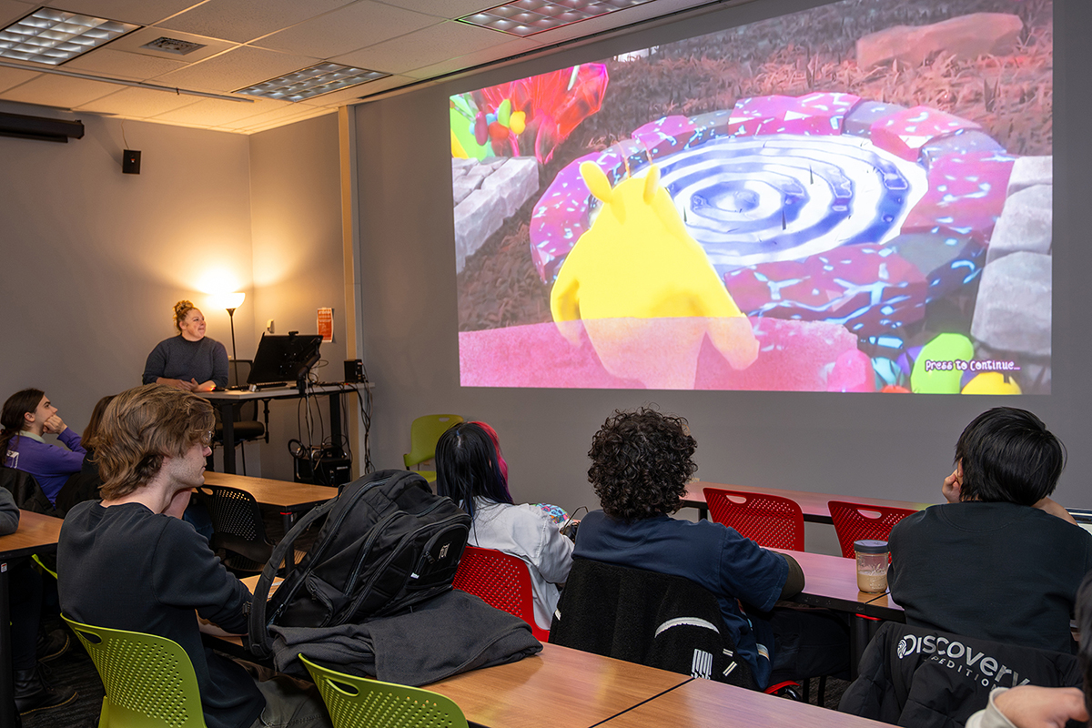 Students watch a projection on a large screen.