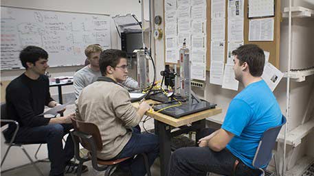 Student sitting around a desk with testing equipment