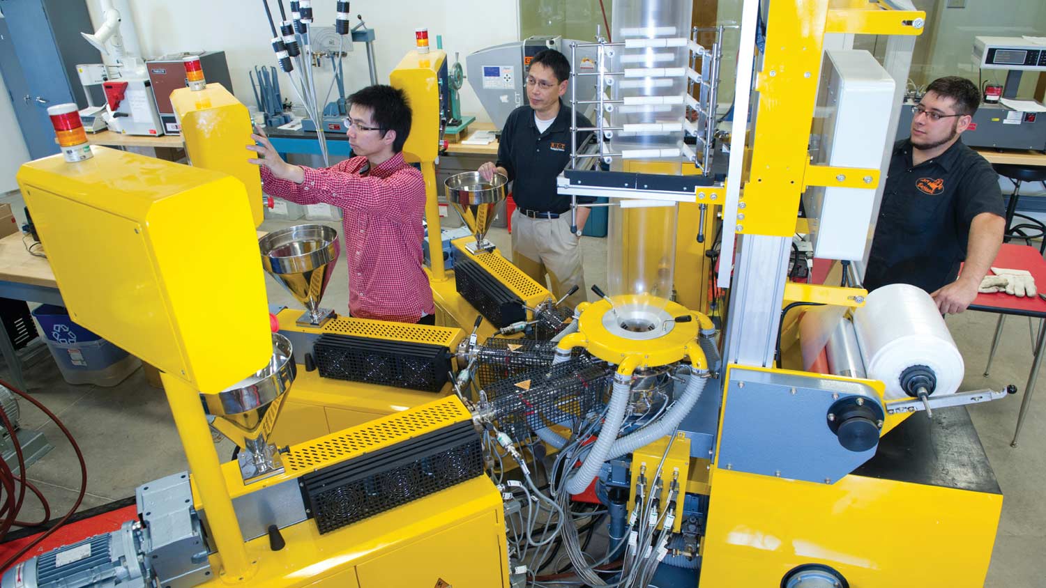 Three people calibrating a large machine