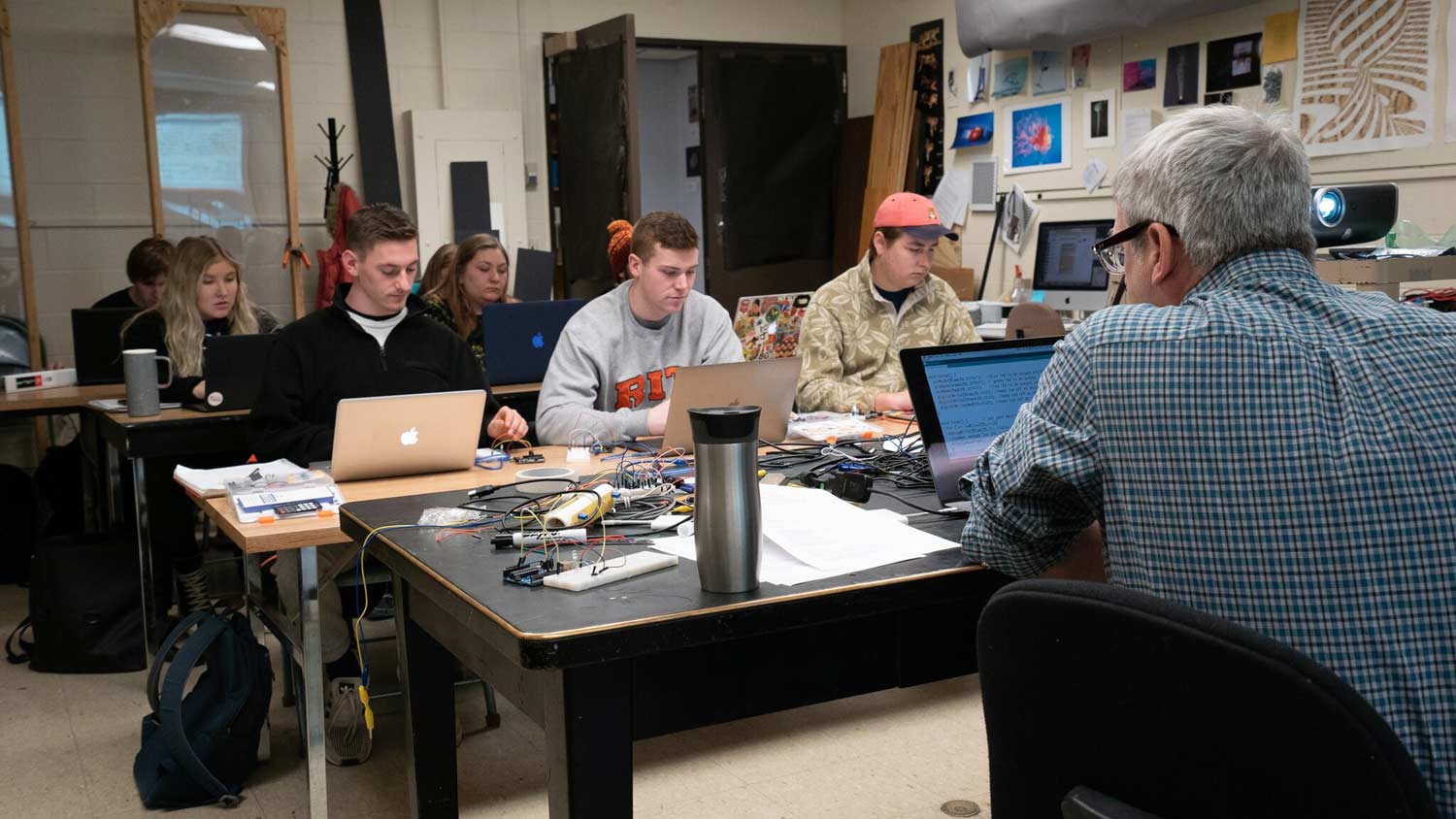 Students working on laptops in a small lab