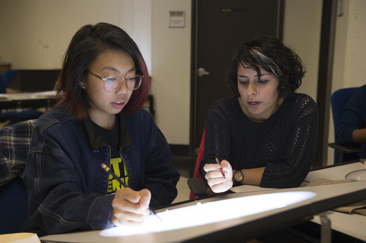 A student works with a faculty member in the Animation Classroom.
