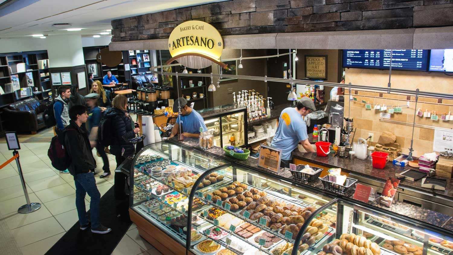 Customers in line next to clear storage racks showing off baked goods.