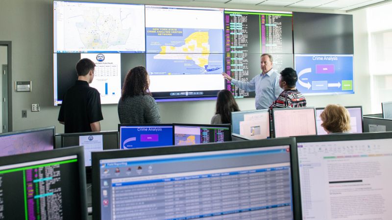 students and professor looking at crime data on large screens
