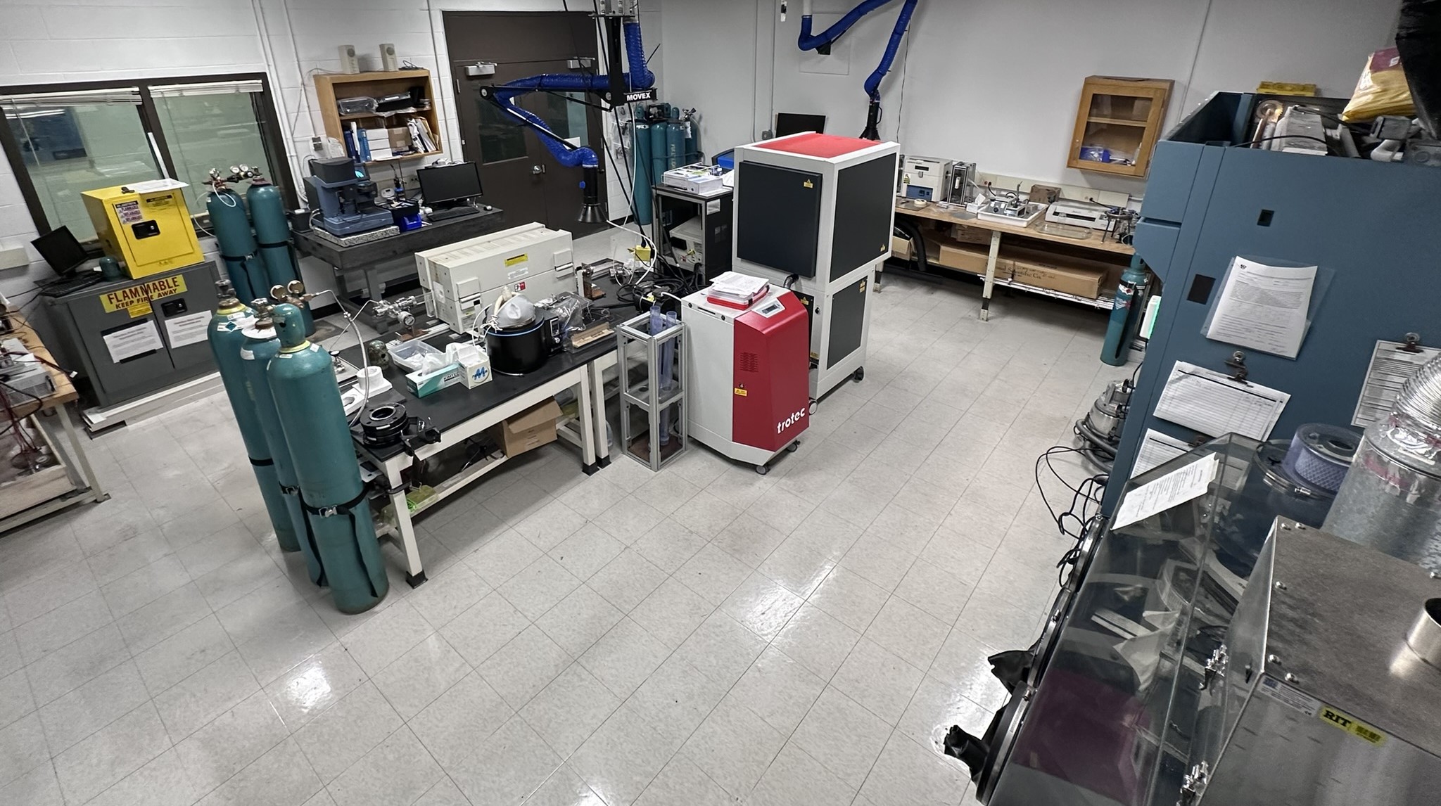 Overhead view of the Carbon Nanomaterials Sythesis and Purification Lab with lab benches along the wals and a central lab bench with gas cylinders to the side of it.