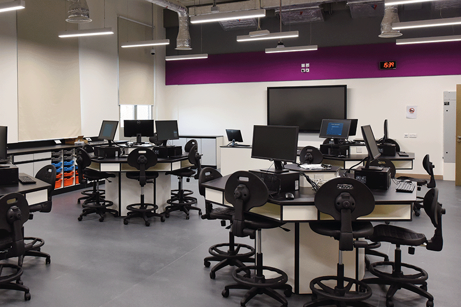 A classroom with computer stations and a television monitor.