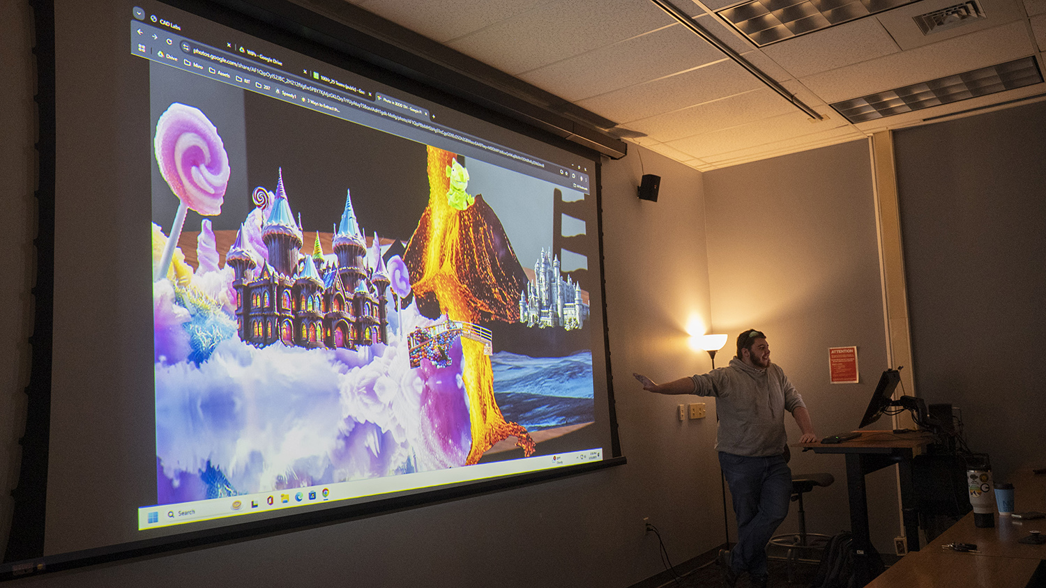 Students project work onto a screen for a critique.