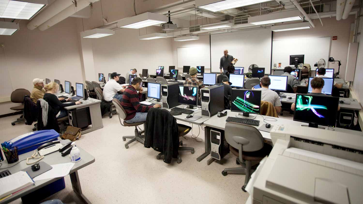 Large computer lab during class with most of the computers in use