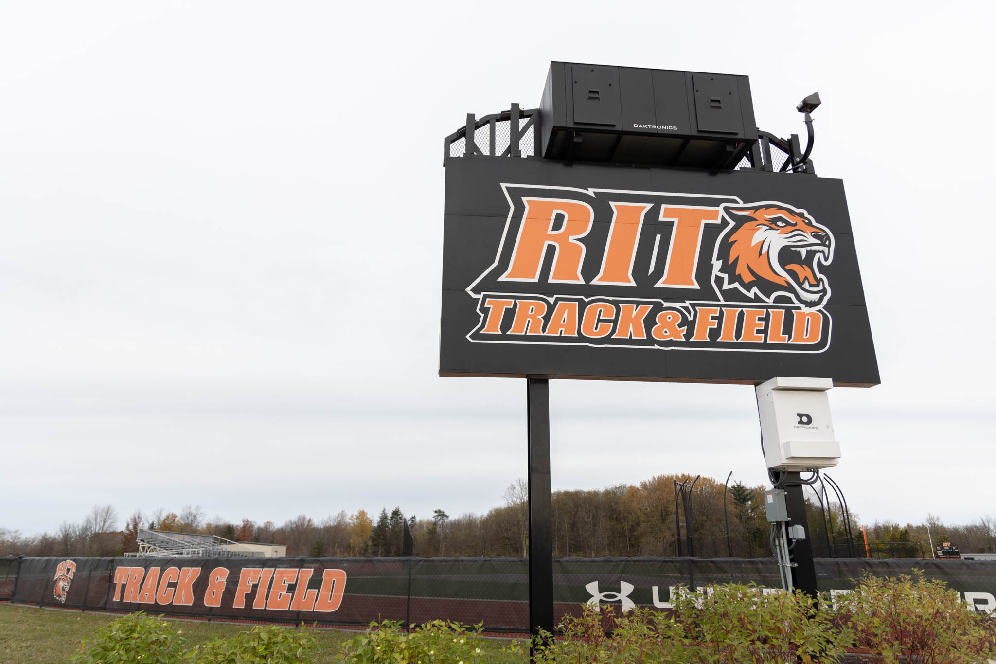 Large sign with text "RIT Track & Field" in orange letters with RIT Tiger head