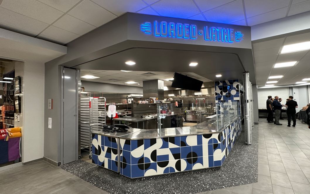 Loaded Latke sign lit up with kitchen and ordering counter below it 