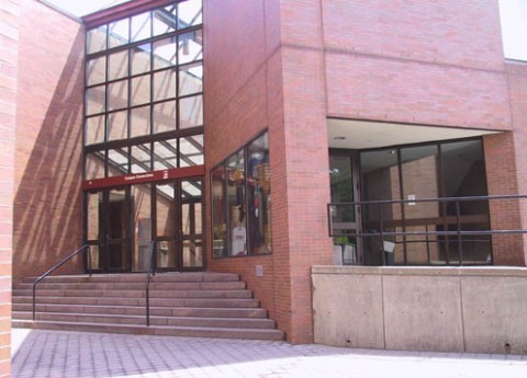 the exterior of a brick building, with steps leading to the entrance.