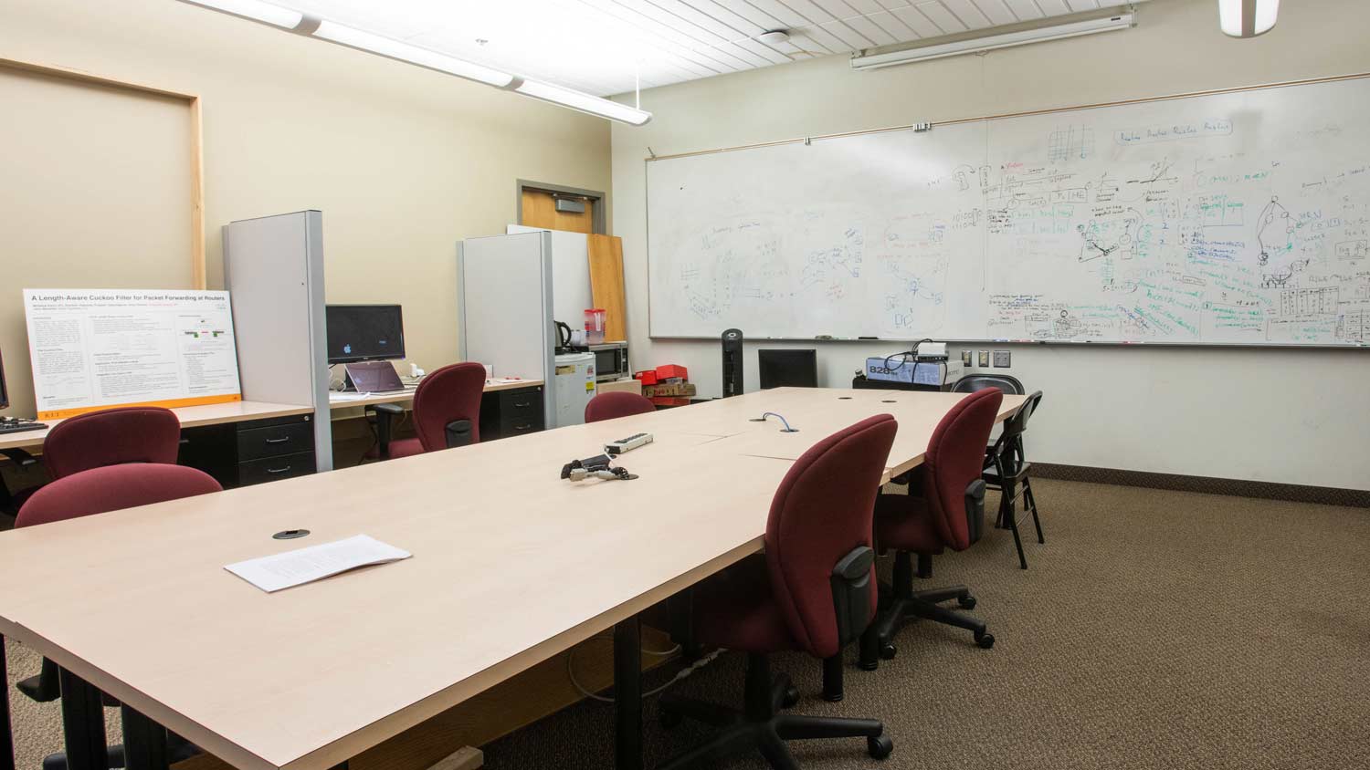 Carpeted room with a large whiteboard and conference table
