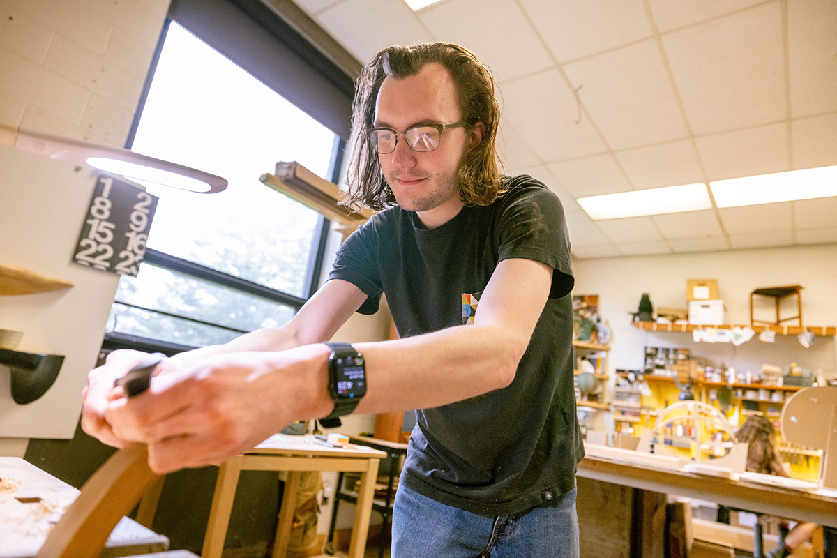 An RIT student works with hand tools in the furniture design studio.