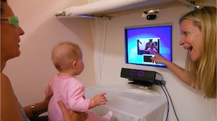 Baby looking at images on computer monitor.