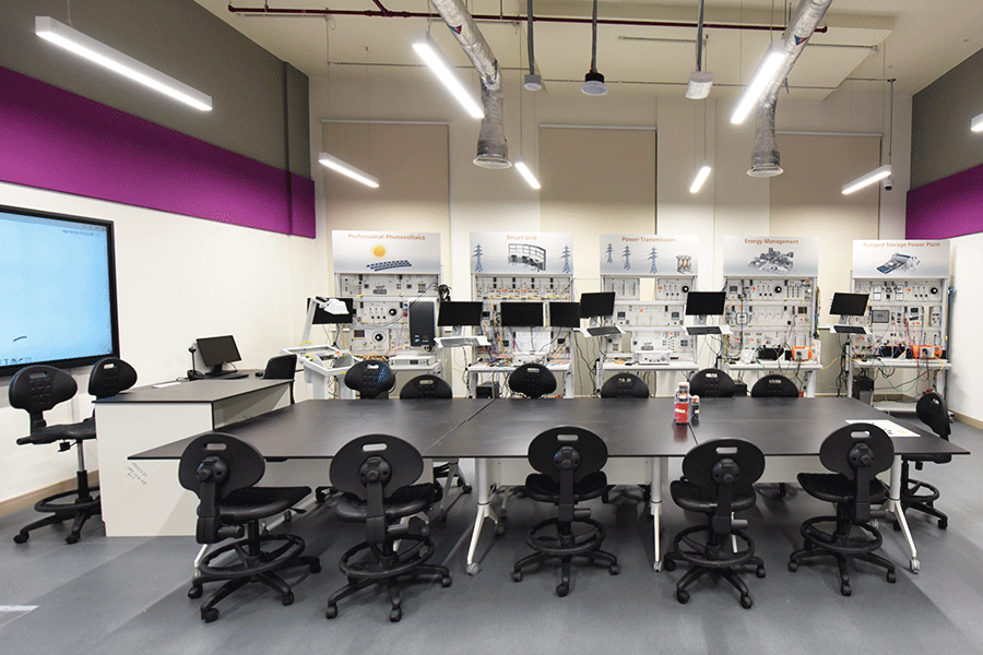 A laboratory with a large table, chairs, and computers.