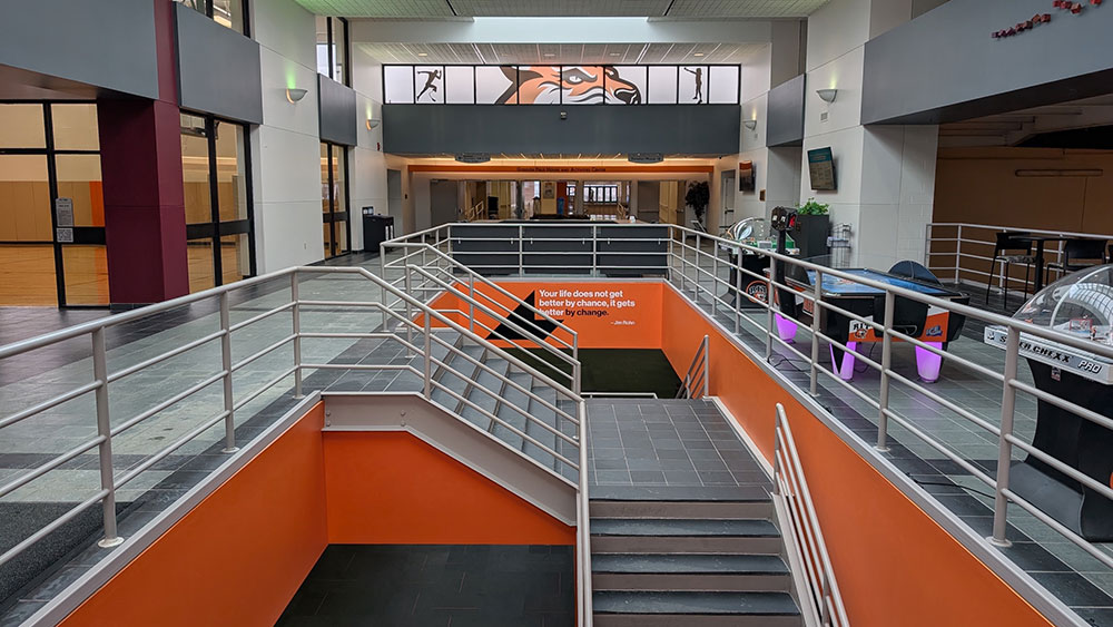lobby area with an air hockey table and stairways that lead to a lower level.