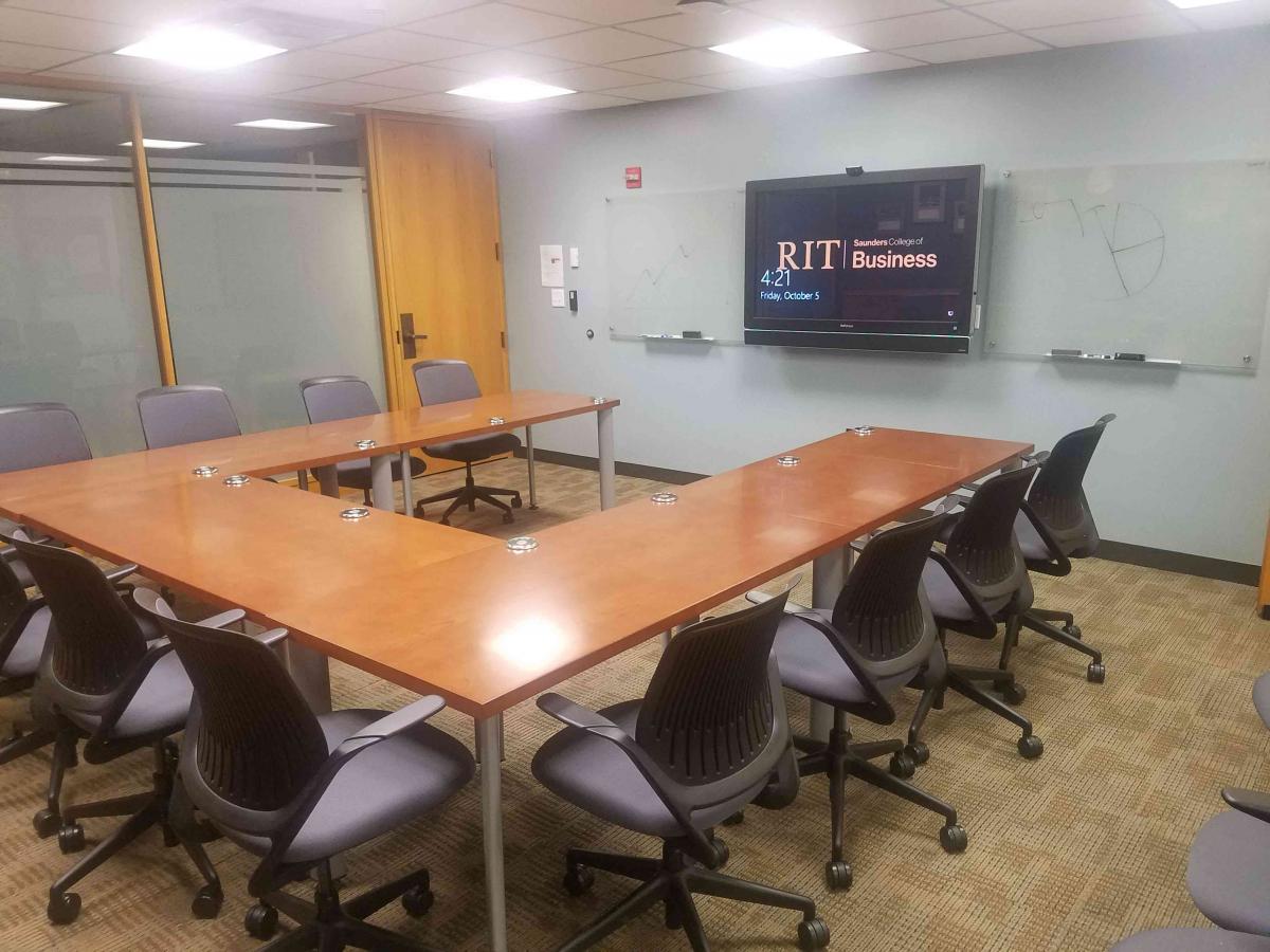U shaped conference table facing a TV and clearboard