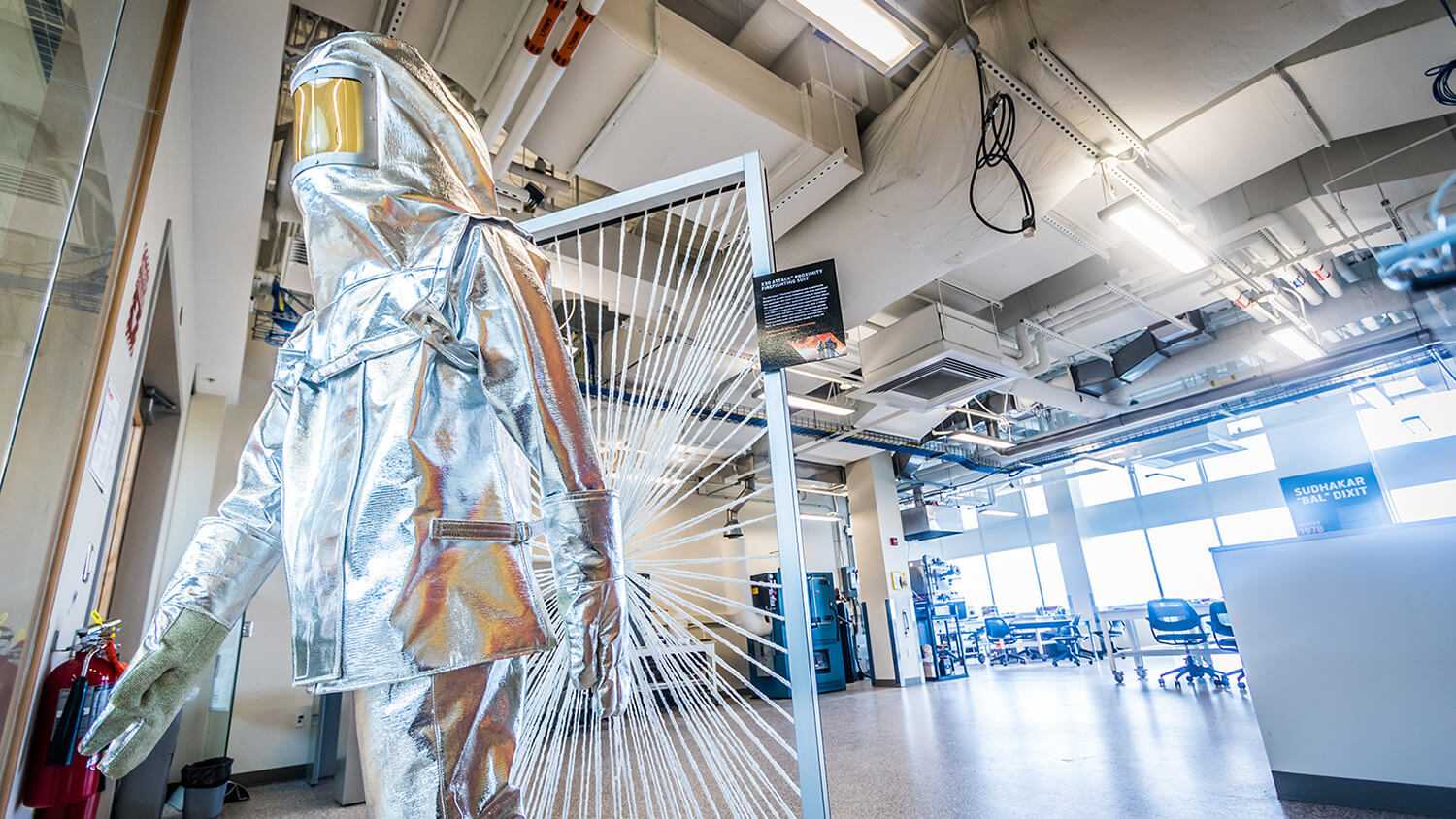 Silver high temperature protective body suit in a lab.