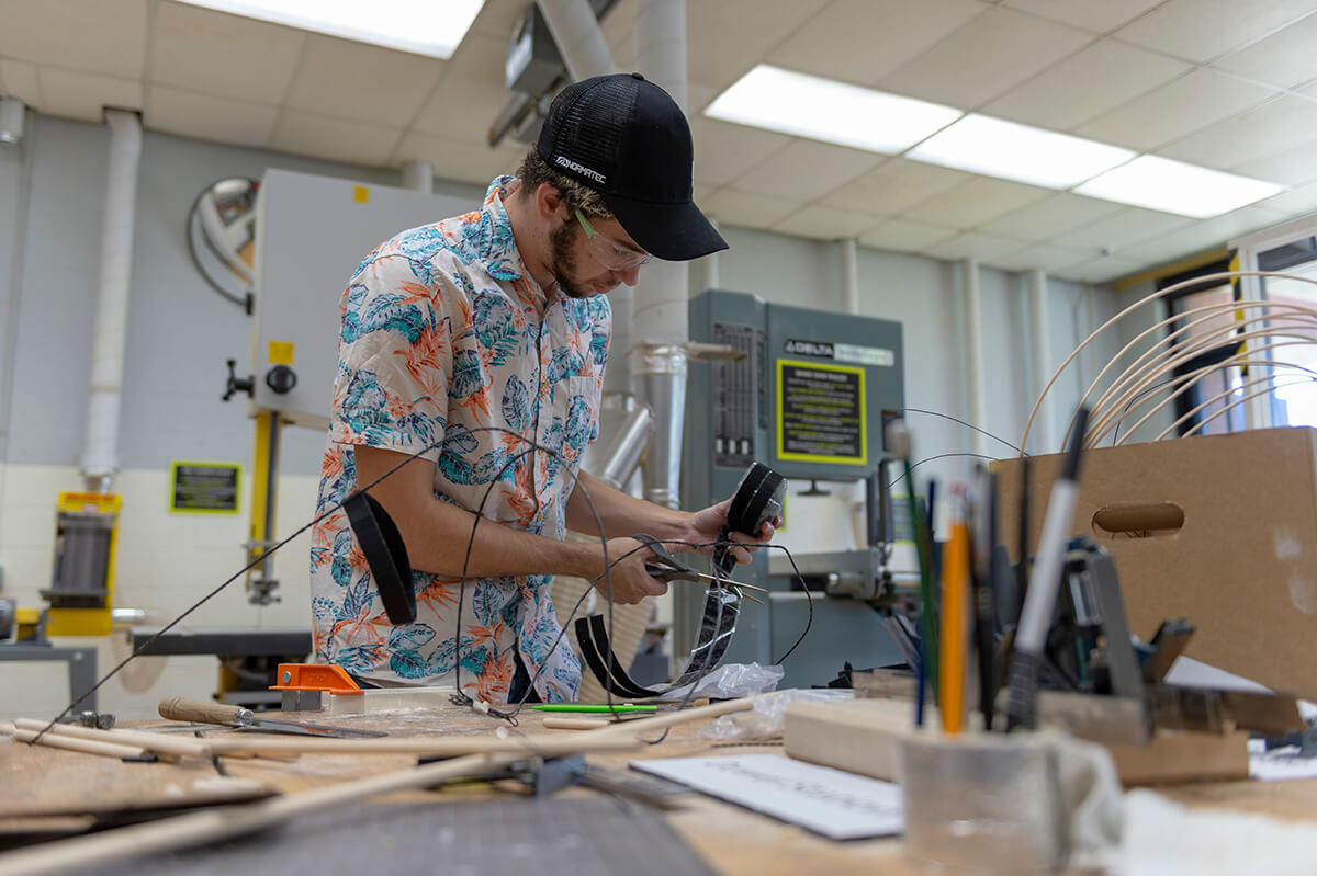 student snips wires in a maker space.