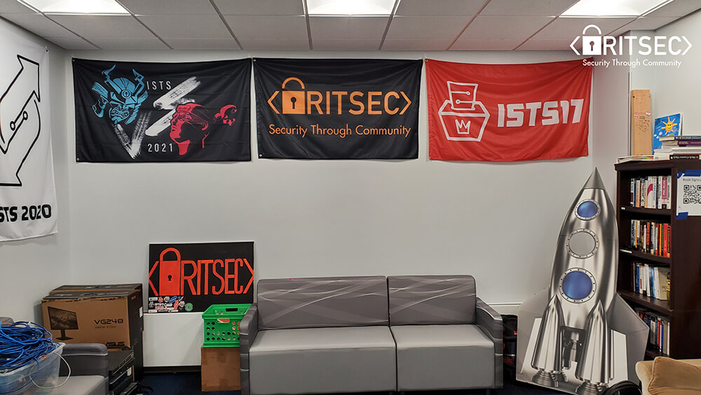 a lounge space with a couch and several banners for the R I T S E C club.