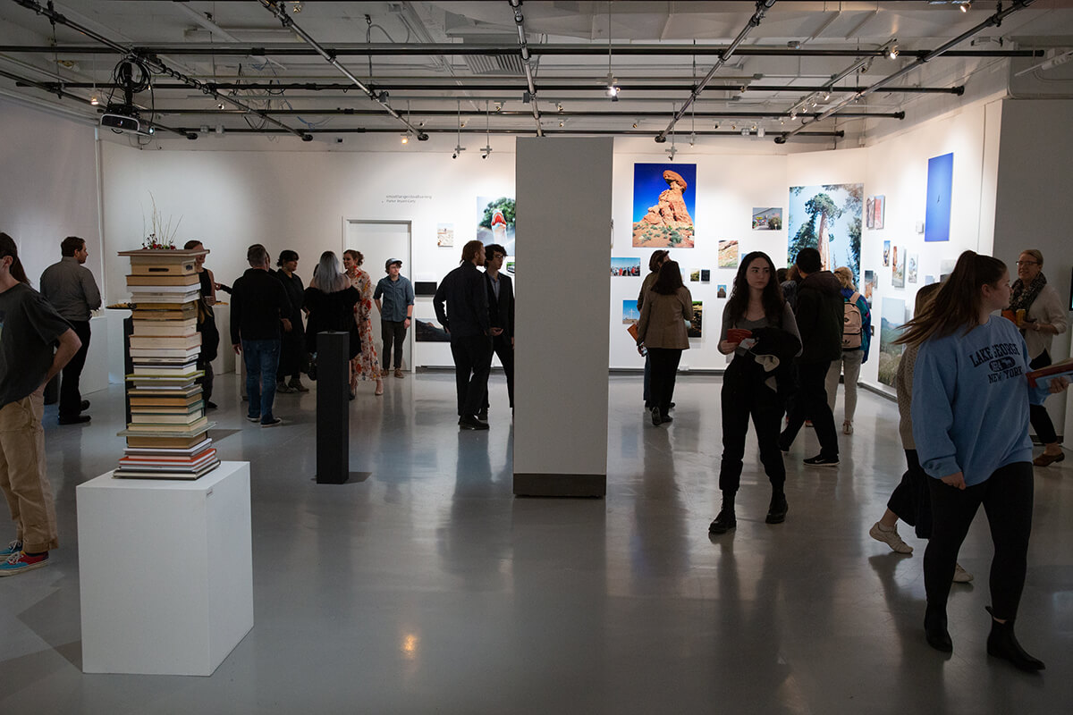 A wide view of a gallery opening of a fine art photography capstone show. 