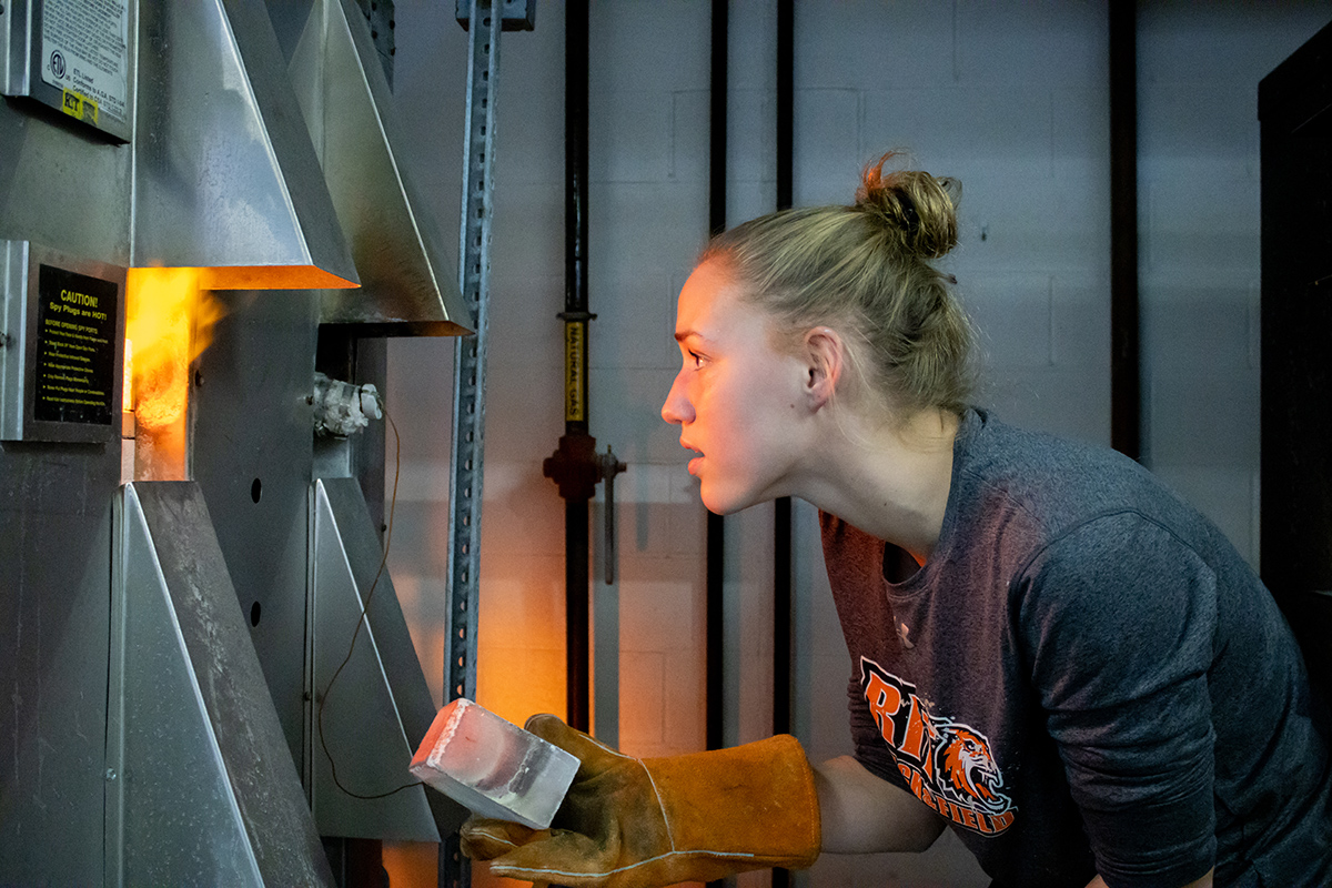 Ceramics student Marian Draper operates a kiln.