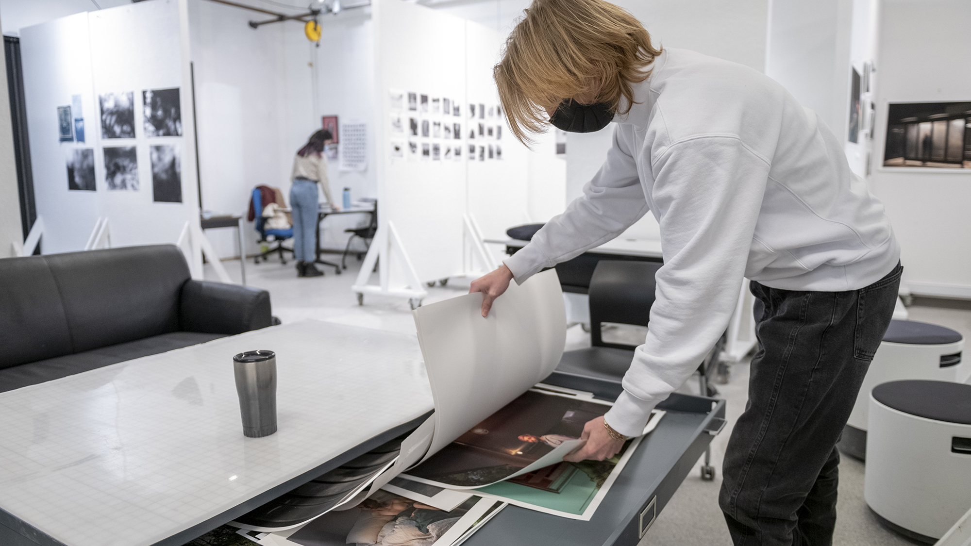 A graduate student flips through photo prints.