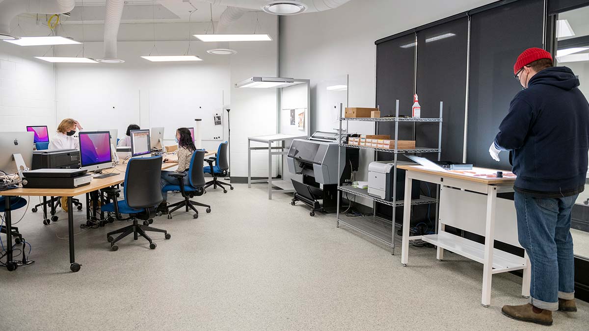 A wide shot of students working in the photo grad lab.