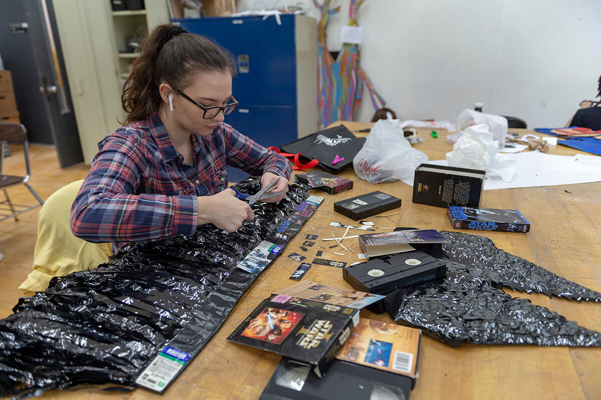 A student makes a wearable sculpture from Star Wars V H S tape.