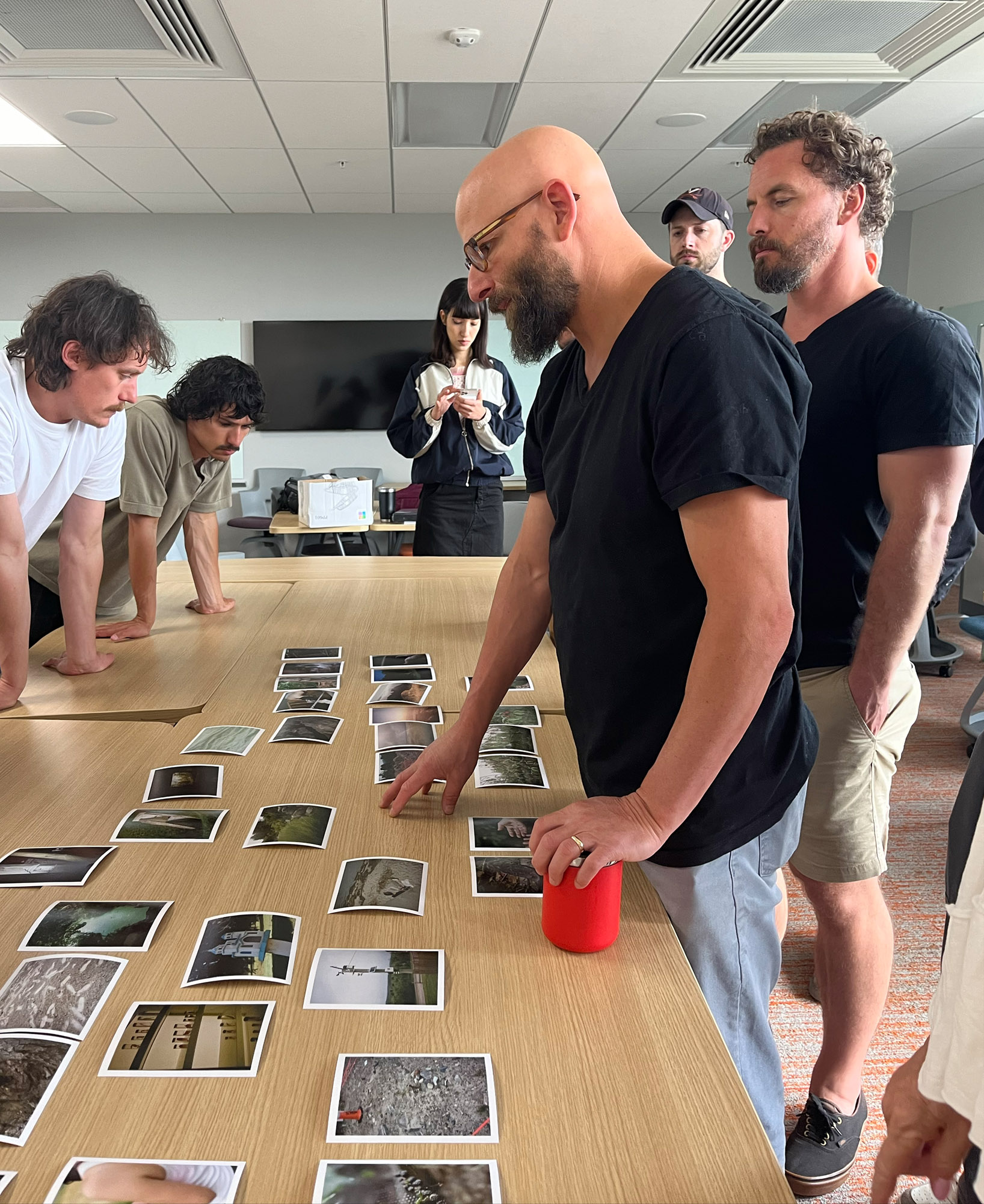 Faculty Greg Halpern looks over photo prints on a table.