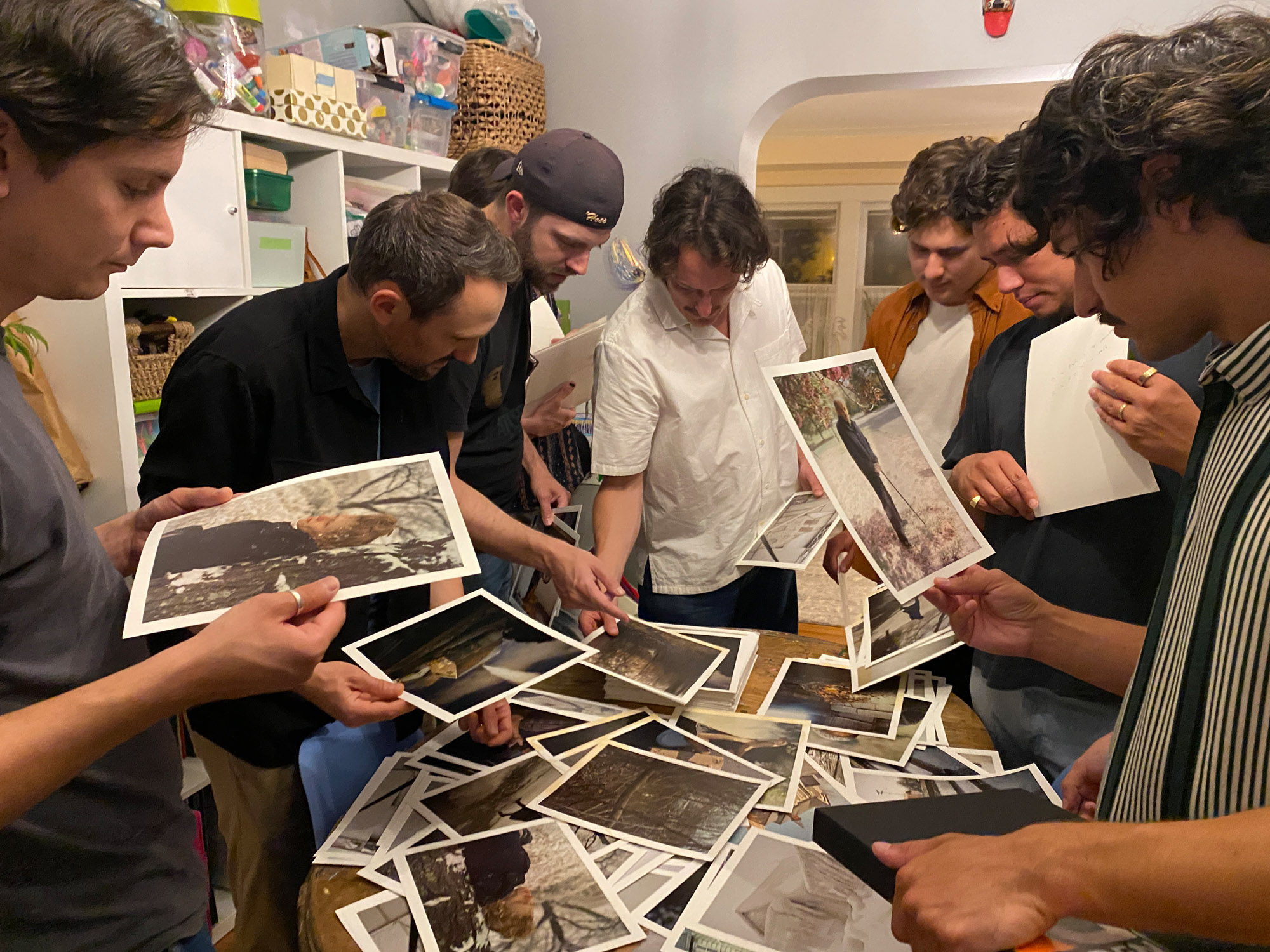 A group of people looks at photo prints.