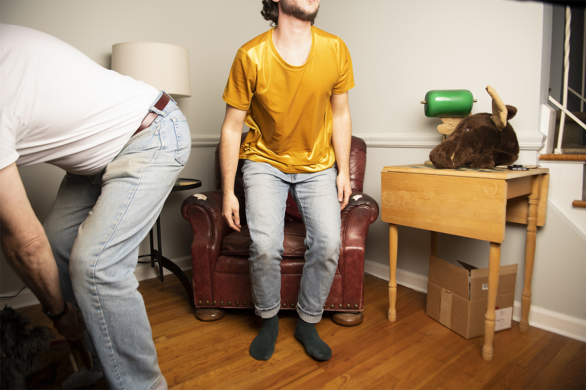 A fine art photo of someone about to take a seat on a chair.