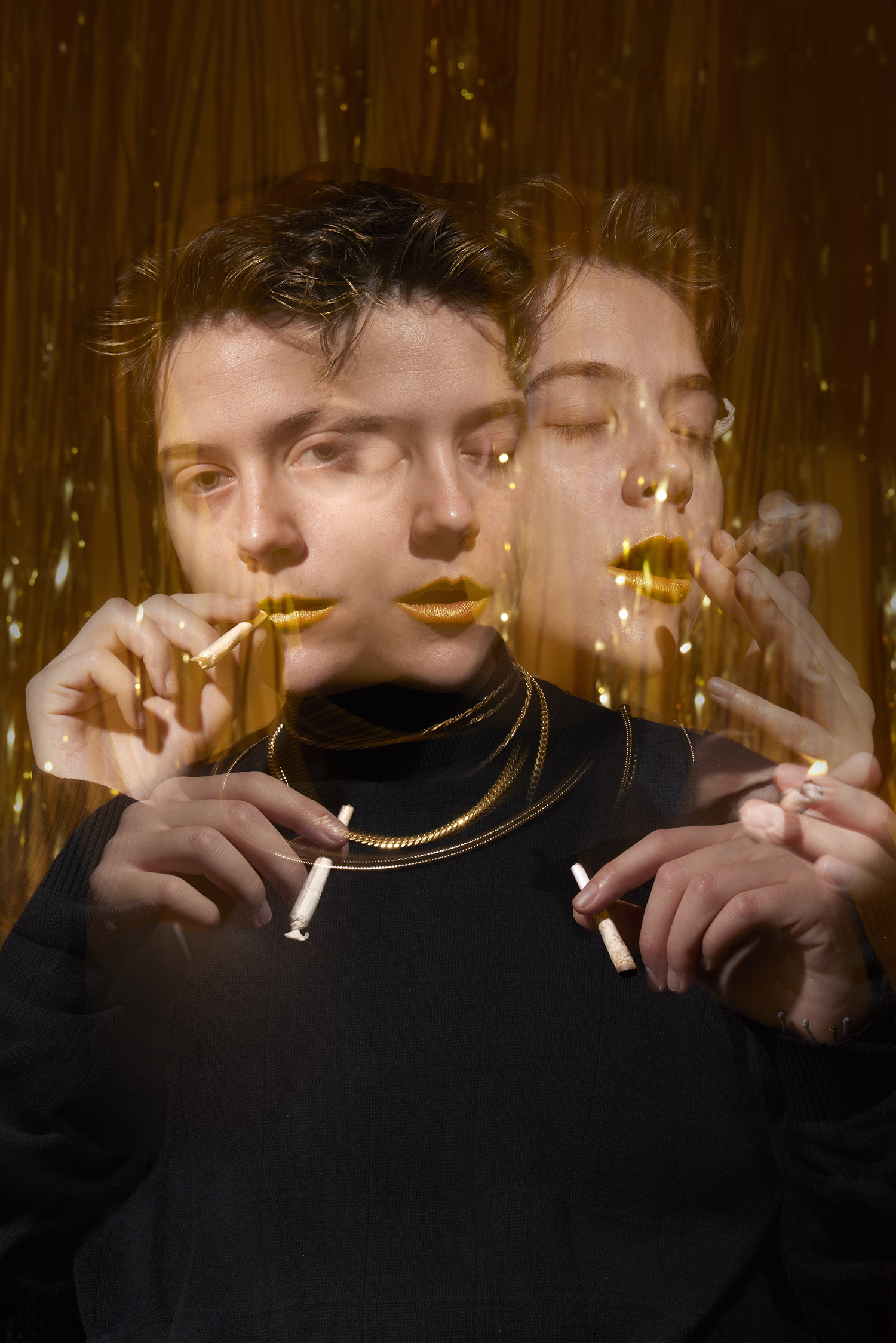 A person smoking against a gold background.