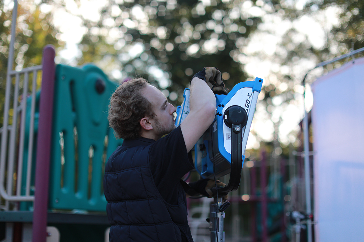 Max Schaefer operates a camera on set.