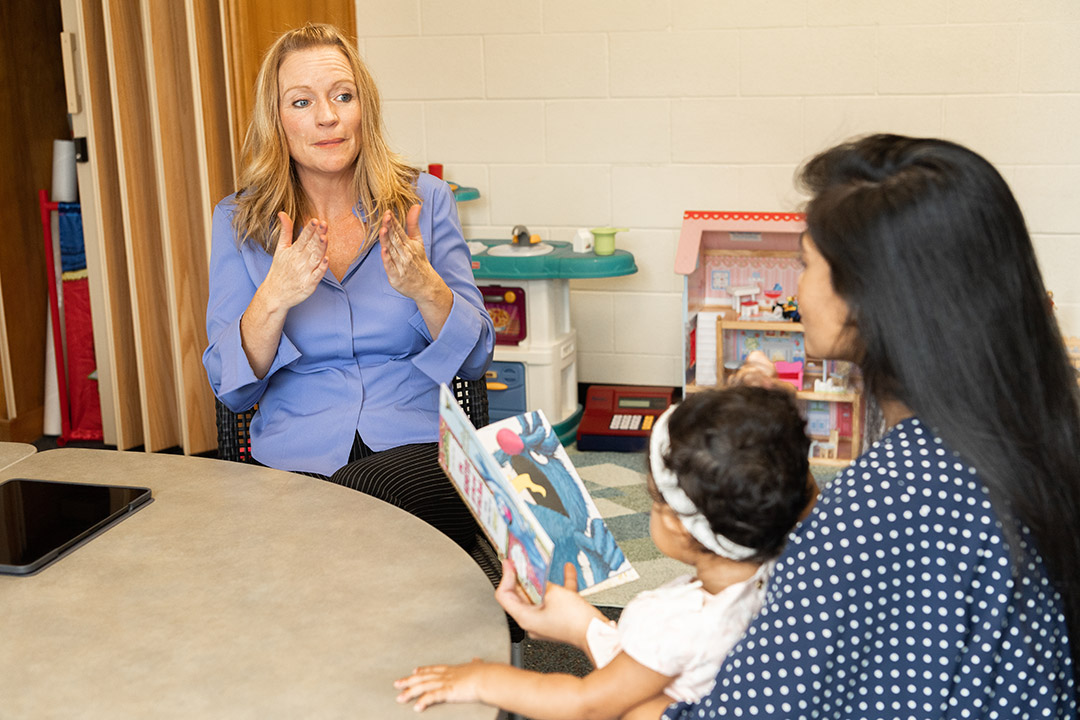 researcher interacting with mother and baby.