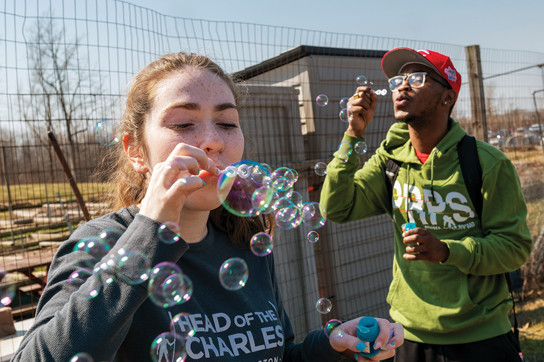two college students blowing soap bubbles.