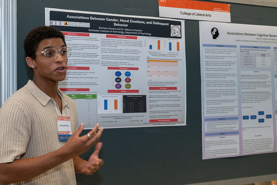 student giving poster presentation.