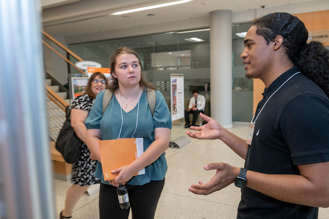 student giving poster presentation.