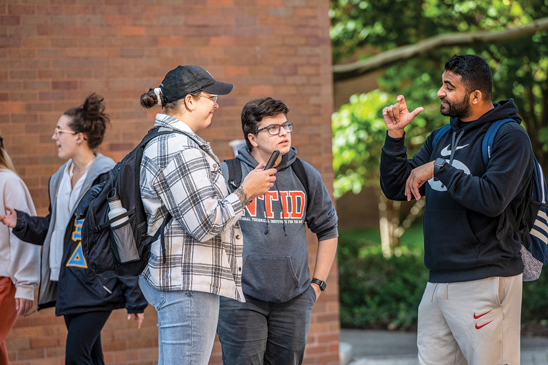 three college students using American Sign Language.