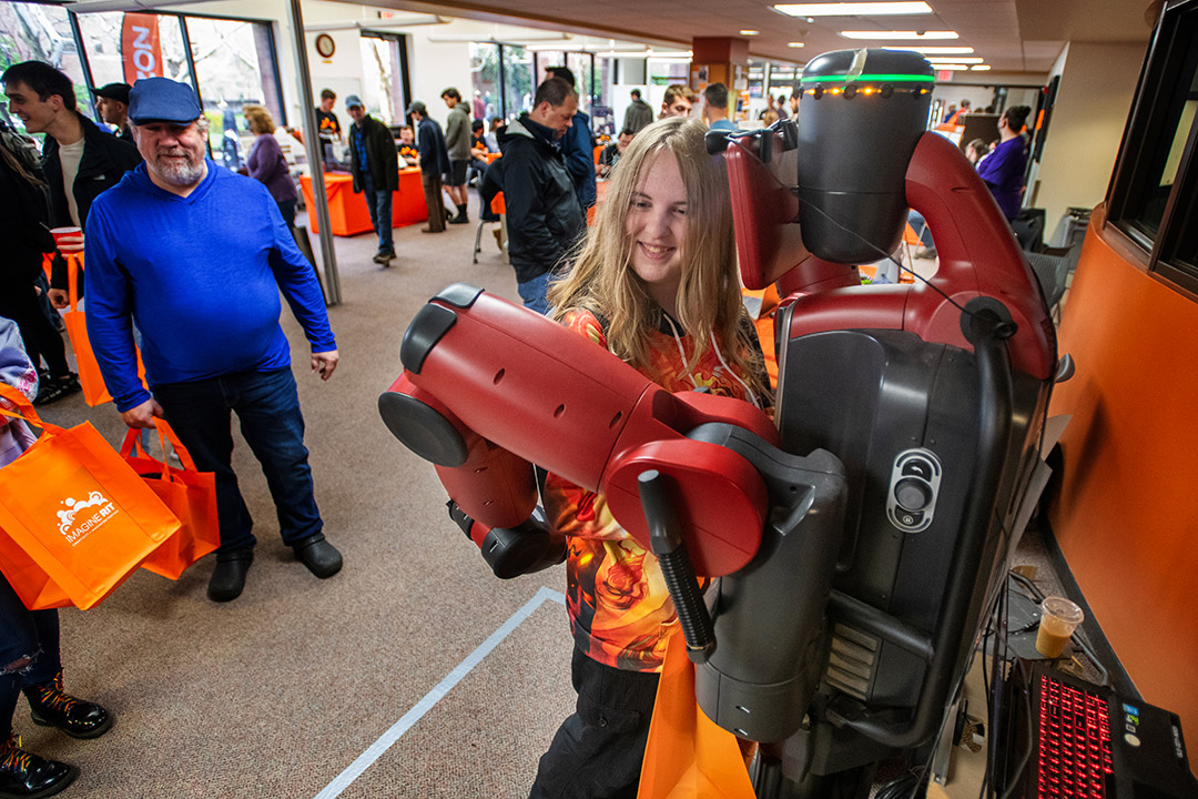 middle school student hugging a robot.