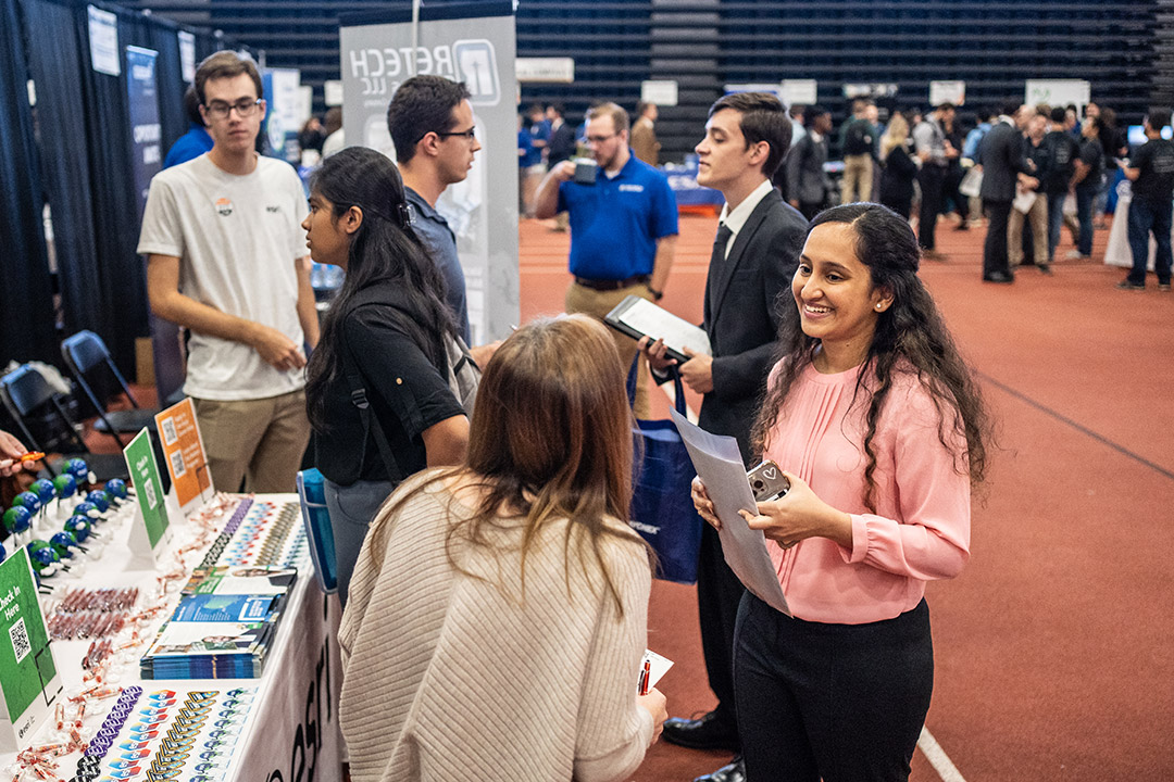 college student talking to recruiter at a career fair.