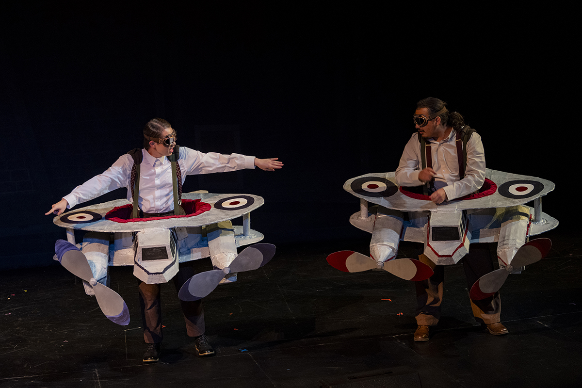 Performers don wearable airplane designs.